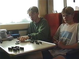 Oliver and Gavin play dominoes with a mother and son who boarded the train at Birmingham